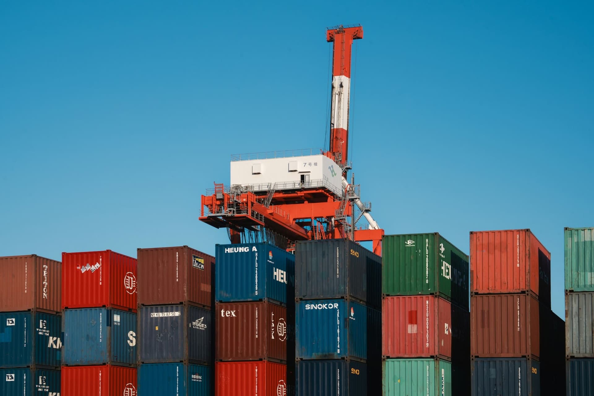 Stacked shipping containers beneath a gantry crane